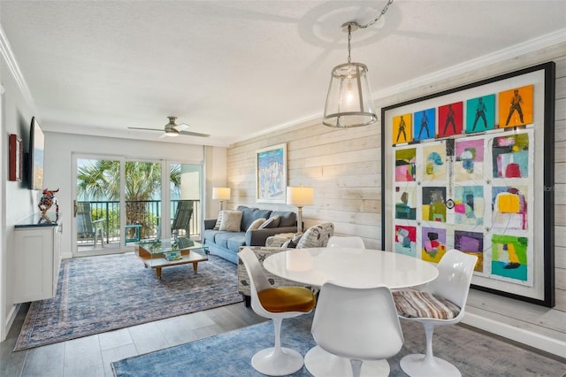 7564 Bayshore Dr Unit 302, Treasure Island, FL 33706 - dining room featuring ornamental molding, wooden walls, wood finished floors, and a ceiling fan