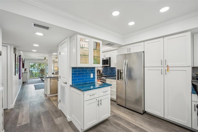 7564 Bayshore Dr Unit 302, Treasure Island, FL 33706 - kitchen featuring appliances with stainless steel finishes, white cabinets, crown molding, glass insert cabinets, and wood finished floors