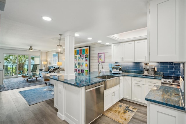 7564 Bayshore Dr Unit 302, Treasure Island, FL 33706 - kitchen with stainless steel dishwasher, a sink, a peninsula, wood finished floors, and ceiling fan