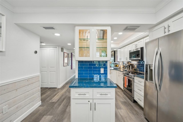 7564 Bayshore Dr Unit 302, Treasure Island, FL 33706 - kitchen with appliances with stainless steel finishes, dark countertops, crown molding, wood finished floors, and white cabinetry