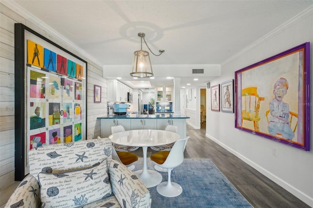 7564 Bayshore Dr Unit 302, Treasure Island, FL 33706 - dining space with crown molding, dark wood finished floors, baseboards, and decorative columns