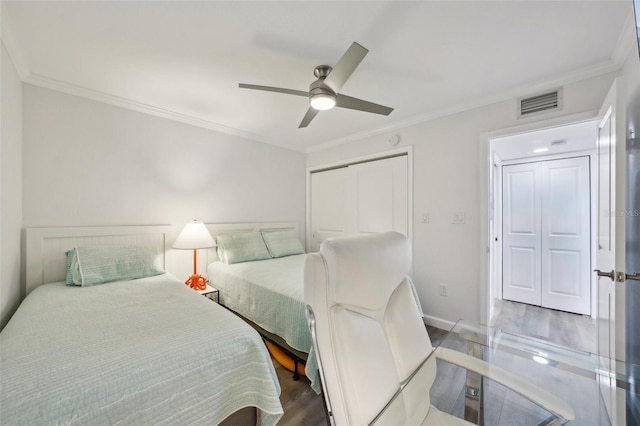 7564 Bayshore Dr Unit 302, Treasure Island, FL 33706 - bedroom featuring ornamental molding, wood finished floors, a closet, a ceiling fan, and baseboards