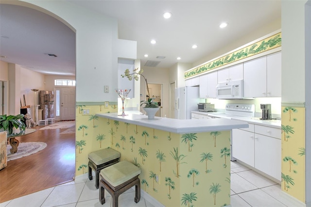 kitchen with white appliances, light countertops, light tile patterned flooring, white cabinetry, and recessed lighting