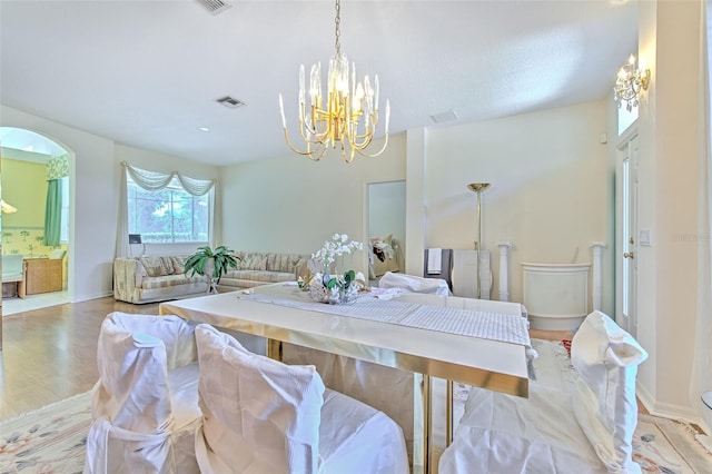 dining space featuring a chandelier, wood finished floors, and baseboards
