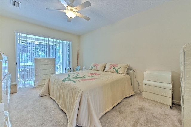 bedroom featuring light carpet, access to exterior, ceiling fan, and a textured ceiling