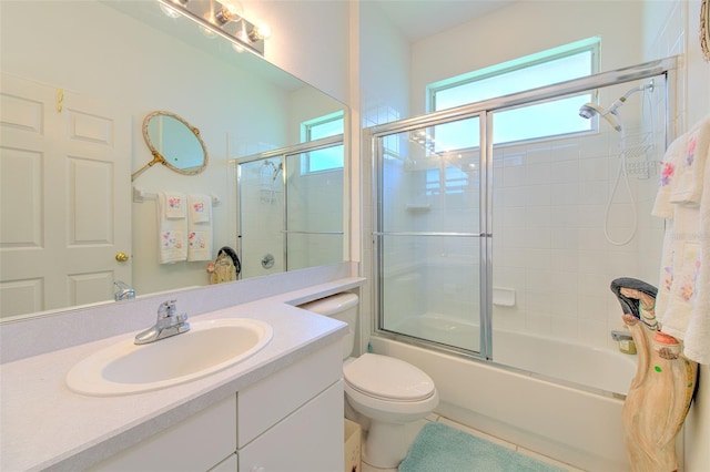 bathroom featuring enclosed tub / shower combo, vanity, toilet, and tile patterned floors