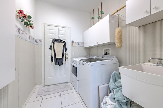 laundry room featuring independent washer and dryer, cabinet space, light marble finish flooring, and baseboards