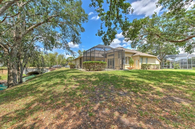 view of grassy yard with a lanai
