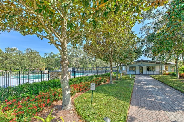 view of front of house featuring a community pool and driveway