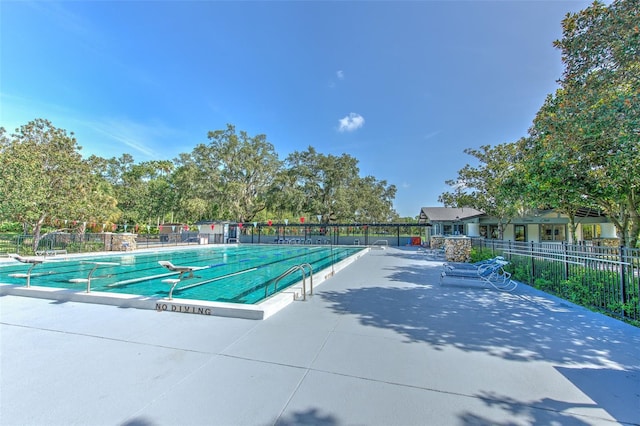 community pool with fence and a patio