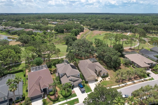 aerial view of residential area featuring a heavily wooded area and a golf club