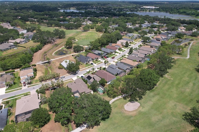 aerial overview of property's location with a nearby body of water, nearby suburban area, and a golf course