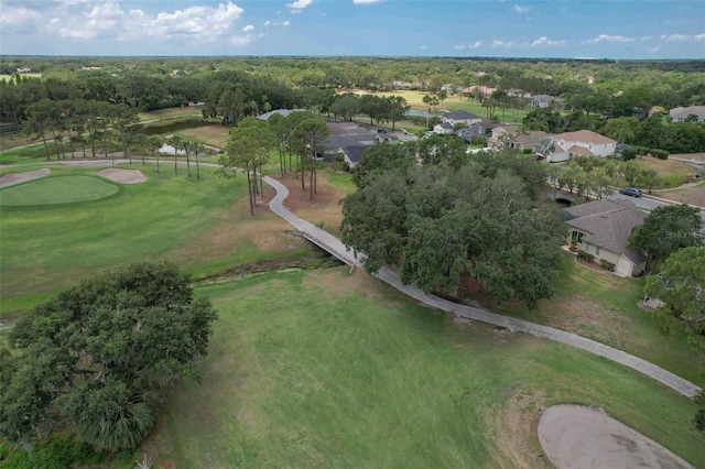 aerial overview of property's location featuring a golf course and nearby suburban area