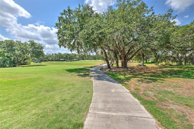 surrounding community with a yard and view of wooded area