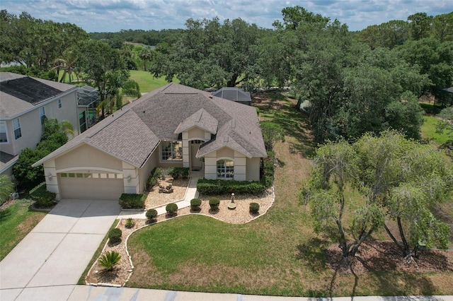 view of front facade with an attached garage, roof with shingles, driveway, stucco siding, and a front lawn