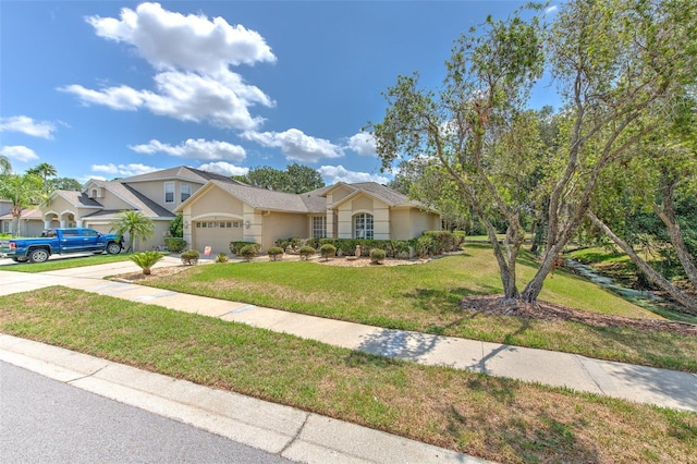 view of front facade with a garage, stucco siding, driveway, and a front yard