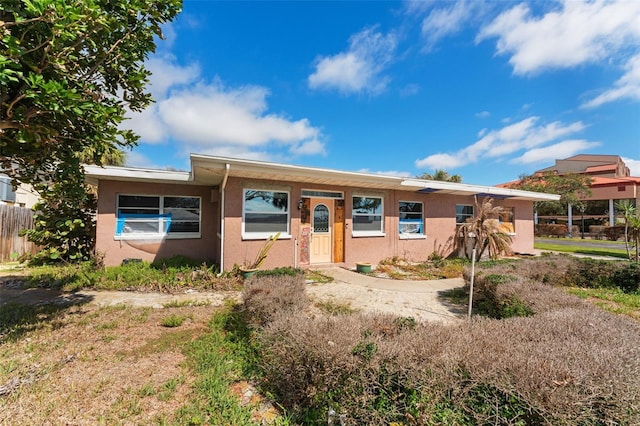 7075 Sunset Dr S, South Pasadena, FL 33707 - view of front of property with stucco siding and fence