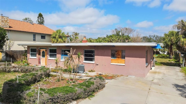 7075 Sunset Dr S, South Pasadena, FL 33707 - view of front facade featuring a chimney, stucco siding, fence, and central air condition unit