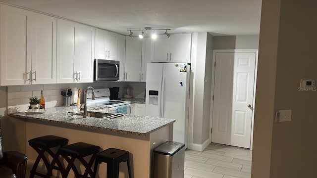 8423 Edgewater Place Blvd, Tampa, FL 33615 - kitchen with white appliances, a peninsula, and white cabinetry