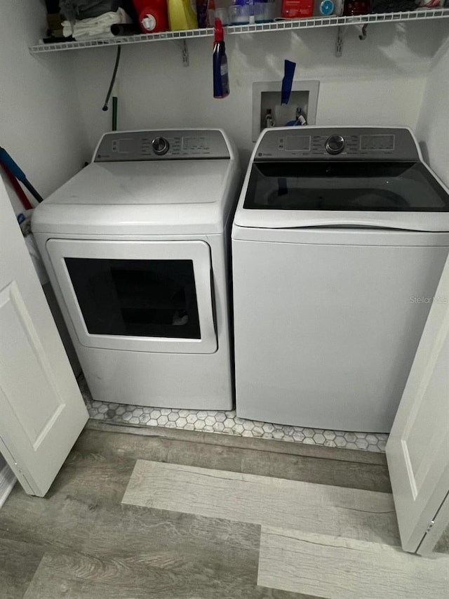 8423 Edgewater Place Blvd, Tampa, FL 33615 - laundry area with washing machine and clothes dryer and wood finished floors