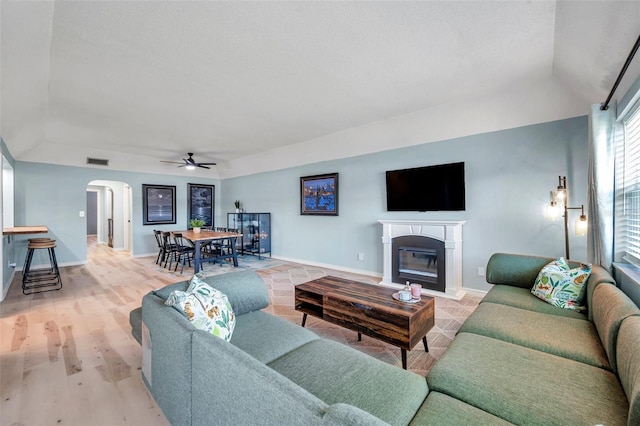 2003 Cordova Grn, Seminole, FL 33777 - living area featuring arched walkways, ceiling fan, a fireplace with flush hearth, baseboards, and vaulted ceiling