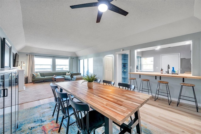 2003 Cordova Grn, Seminole, FL 33777 - dining space featuring a textured ceiling, light wood-type flooring, a ceiling fan, arched walkways, and lofted ceiling