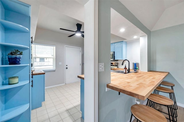 2003 Cordova Grn, Seminole, FL 33777 - kitchen featuring a sink, a kitchen breakfast bar, wooden counters, baseboards, and a peninsula