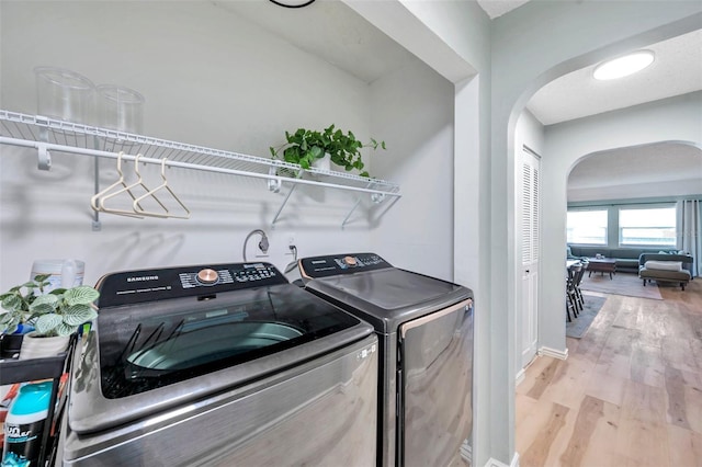 2003 Cordova Grn, Seminole, FL 33777 - laundry room featuring separate washer and dryer, arched walkways, and wood finished floors