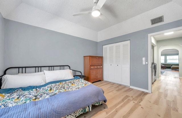 2003 Cordova Grn, Seminole, FL 33777 - bedroom featuring light wood finished floors, arched walkways, a textured ceiling, a closet, and ceiling fan