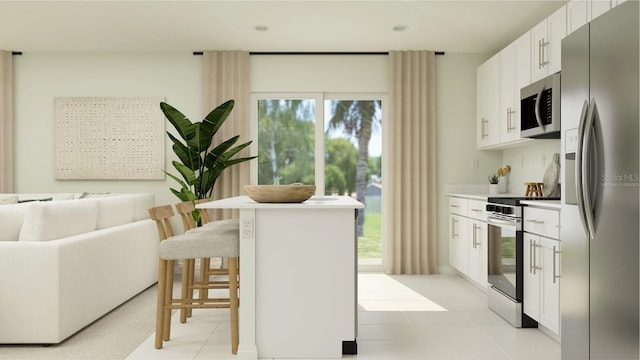 kitchen featuring stainless steel appliances, white cabinets, a breakfast bar area, open floor plan, and light countertops