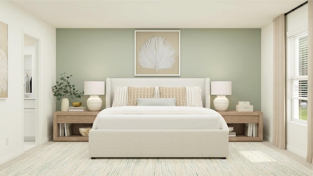carpeted bedroom with multiple windows, baseboards, and ensuite bathroom