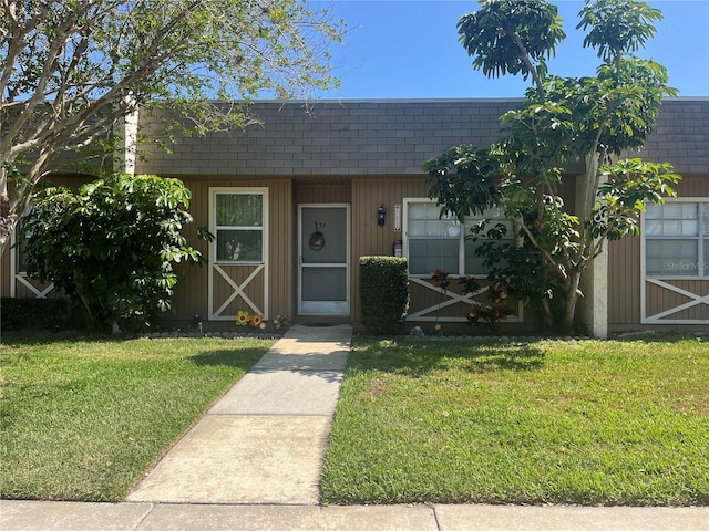 11511 113th St Unit 5C, Largo, FL 33778 - view of property with a shingled roof, a front lawn, and mansard roof