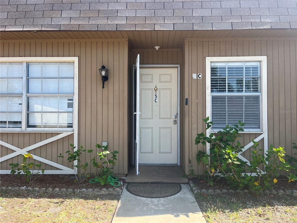 11511 113th St Unit 5C, Largo, FL 33778 - view of exterior entry featuring a shingled roof