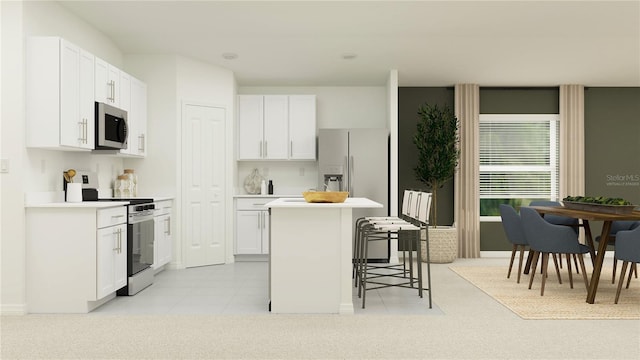 kitchen with appliances with stainless steel finishes, a center island, a breakfast bar, and white cabinetry