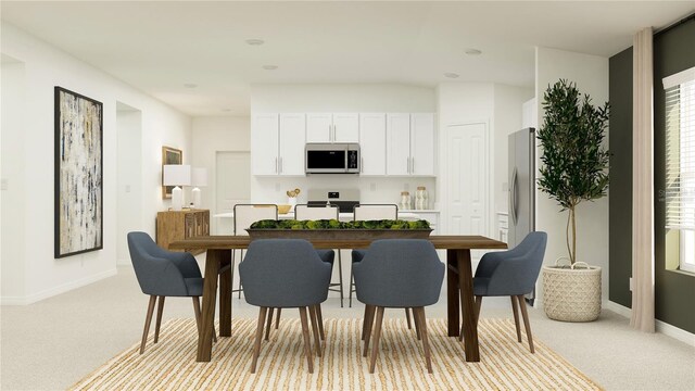 kitchen featuring stove, light carpet, white cabinets, baseboards, and plenty of natural light