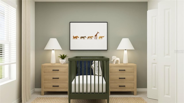 carpeted bedroom with baseboards and a nursery area