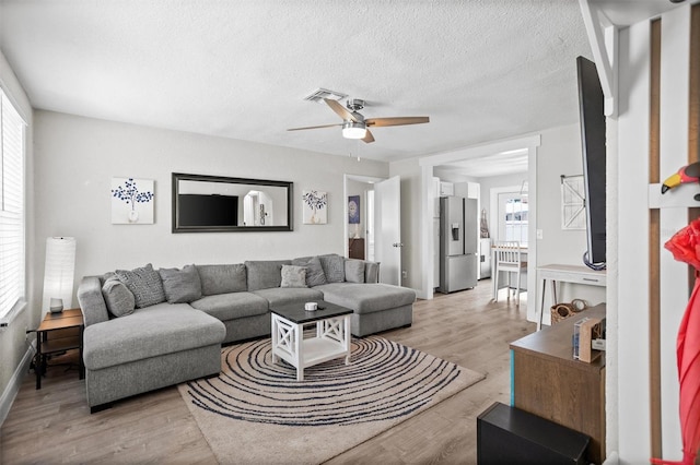 3245 Freemont Ter S, Saint Petersburg, FL 33712 - living area featuring ceiling fan, light wood finished floors, a textured ceiling, and baseboards