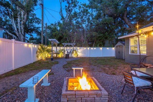 3245 Freemont Ter S, Saint Petersburg, FL 33712 - fenced backyard featuring a fire pit, a shed, an outdoor structure, and a patio area