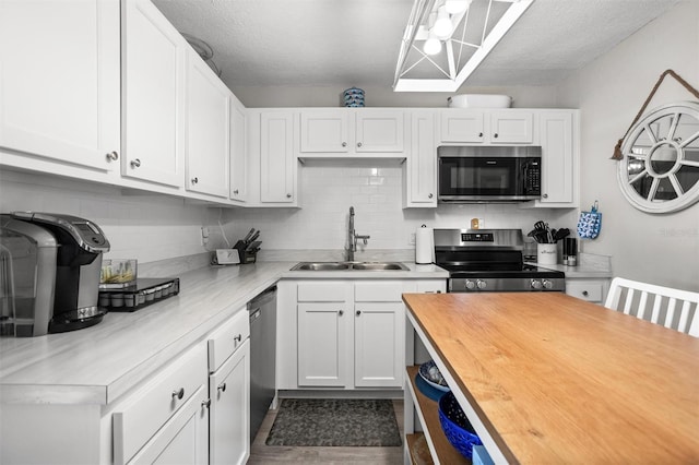 3245 Freemont Ter S, Saint Petersburg, FL 33712 - kitchen featuring stainless steel appliances, a sink, butcher block counters, white cabinets, and backsplash
