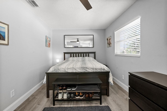 3245 Freemont Ter S, Saint Petersburg, FL 33712 - bedroom with a textured ceiling, light wood-style floors, ceiling fan, and baseboards