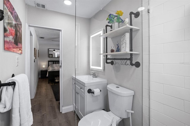 3245 Freemont Ter S, Saint Petersburg, FL 33712 - bathroom with vanity, wood finished floors, toilet, connected bathroom, and baseboards