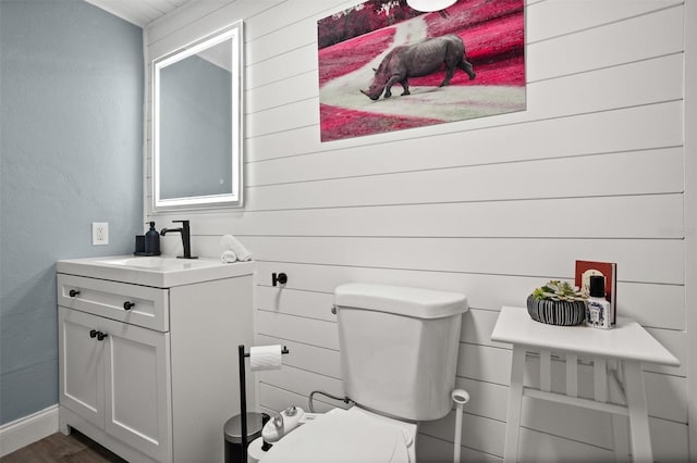 3245 Freemont Ter S, Saint Petersburg, FL 33712 - half bath with vanity, toilet, wooden walls, wood finished floors, and baseboards