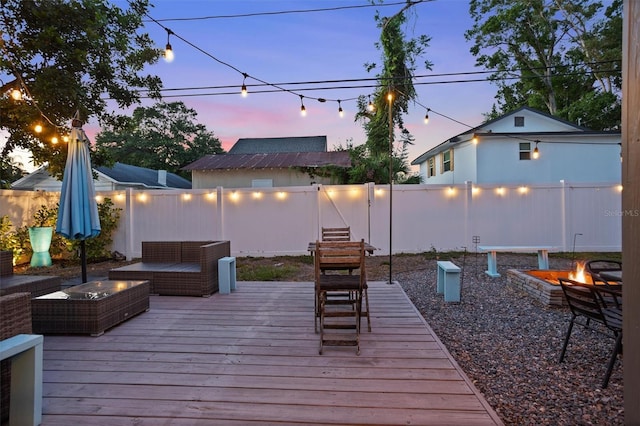 3245 Freemont Ter S, Saint Petersburg, FL 33712 - deck at dusk featuring a fenced backyard and an outdoor living space with a fire pit