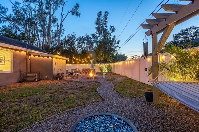 3245 Freemont Ter S, Saint Petersburg, FL 33712 - yard at dusk with a fire pit, a patio area, and a fenced backyard