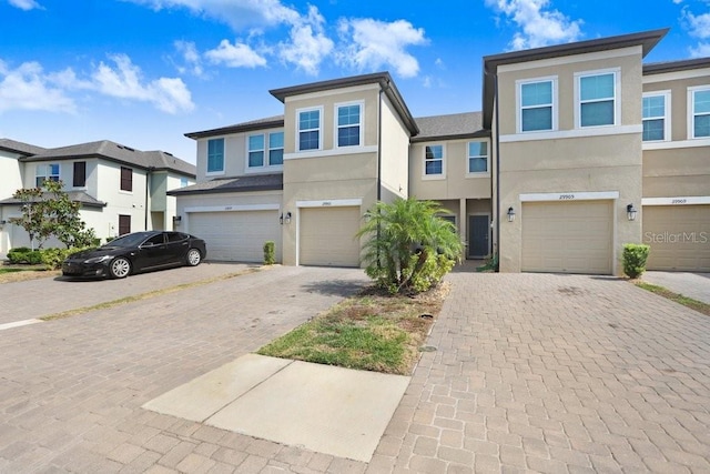29901 Southwell Ln, Wesley Chapel, FL 33543 - view of front of property with stucco siding, a garage, and driveway