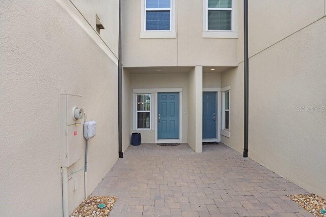 29901 Southwell Ln, Wesley Chapel, FL 33543 - doorway to property with stucco siding and a patio area
