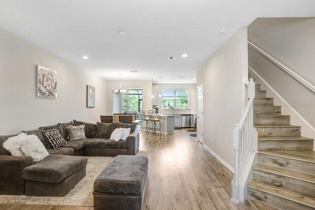 29901 Southwell Ln, Wesley Chapel, FL 33543 - living room with stairs, light wood-style flooring, recessed lighting, and a chandelier