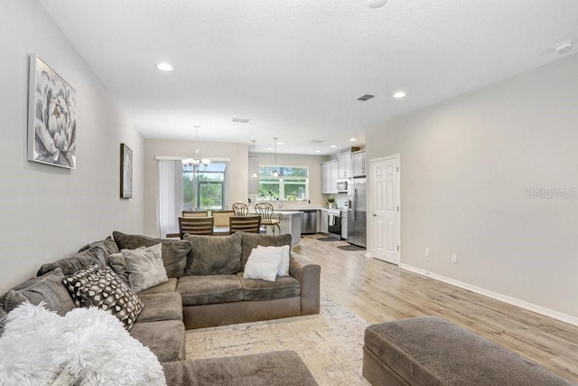 29901 Southwell Ln, Wesley Chapel, FL 33543 - living area with light wood-type flooring, a chandelier, recessed lighting, and baseboards