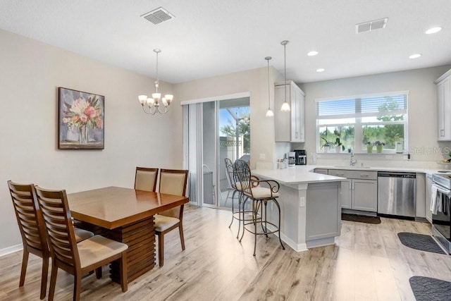 29901 Southwell Ln, Wesley Chapel, FL 33543 - kitchen with stainless steel dishwasher, plenty of natural light, light wood-style flooring, light countertops, and recessed lighting