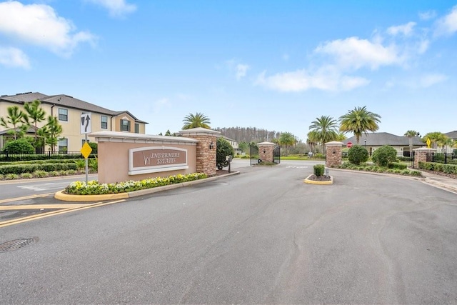 29901 Southwell Ln, Wesley Chapel, FL 33543 - view of asphalt street with traffic signs, curbs, a gated entry, and a residential view